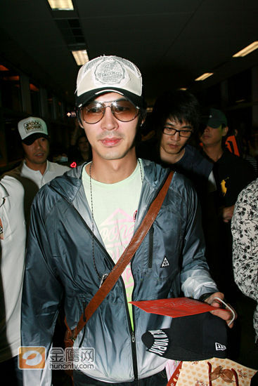 JunJin 一身牛仔外套，头戴棒球帽，心情很好，还不停喝歌迷打招呼