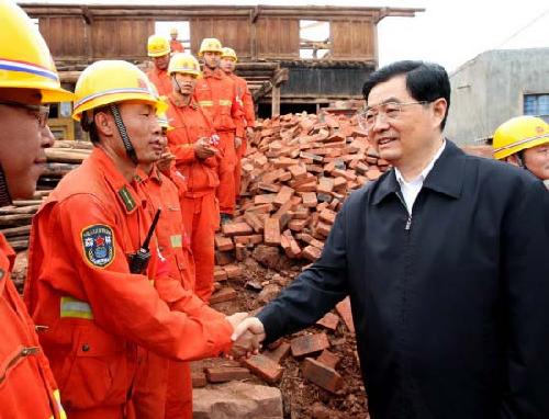 胡锦涛在震中官屯乡官屯村看望正在清理废墟的武警官兵。新华社发