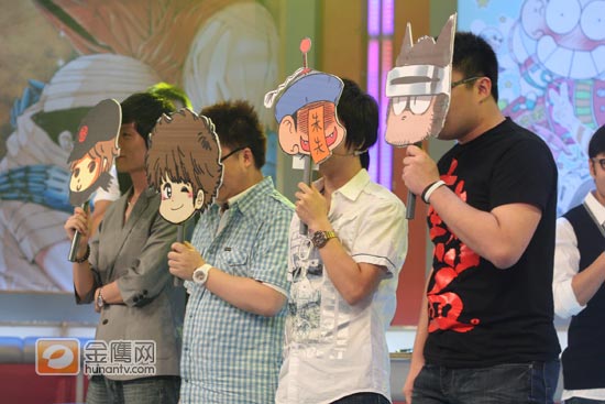 金鹰娱乐讯 四位新生代的漫画家做客《越策》，并在现场与主持人汪涵、马可一同创作漫画。节目中汪涵、马可不仅大秀自己的漫画作品，还现场拍卖，结果最后只有观众愿意出5元买下，引得现场爆笑不断。四位漫画家不仅多次短时间即兴创作出让人叹为观止的作品，还爆料了自己曾经的梦想，更由于现场观众的积极互动参与，节目录制中一直欢声笑语不断。图为四位漫画家手举自画像遮面出场。（摄影：杨扬 金鹰网独家稿件，转载请注明出处。）